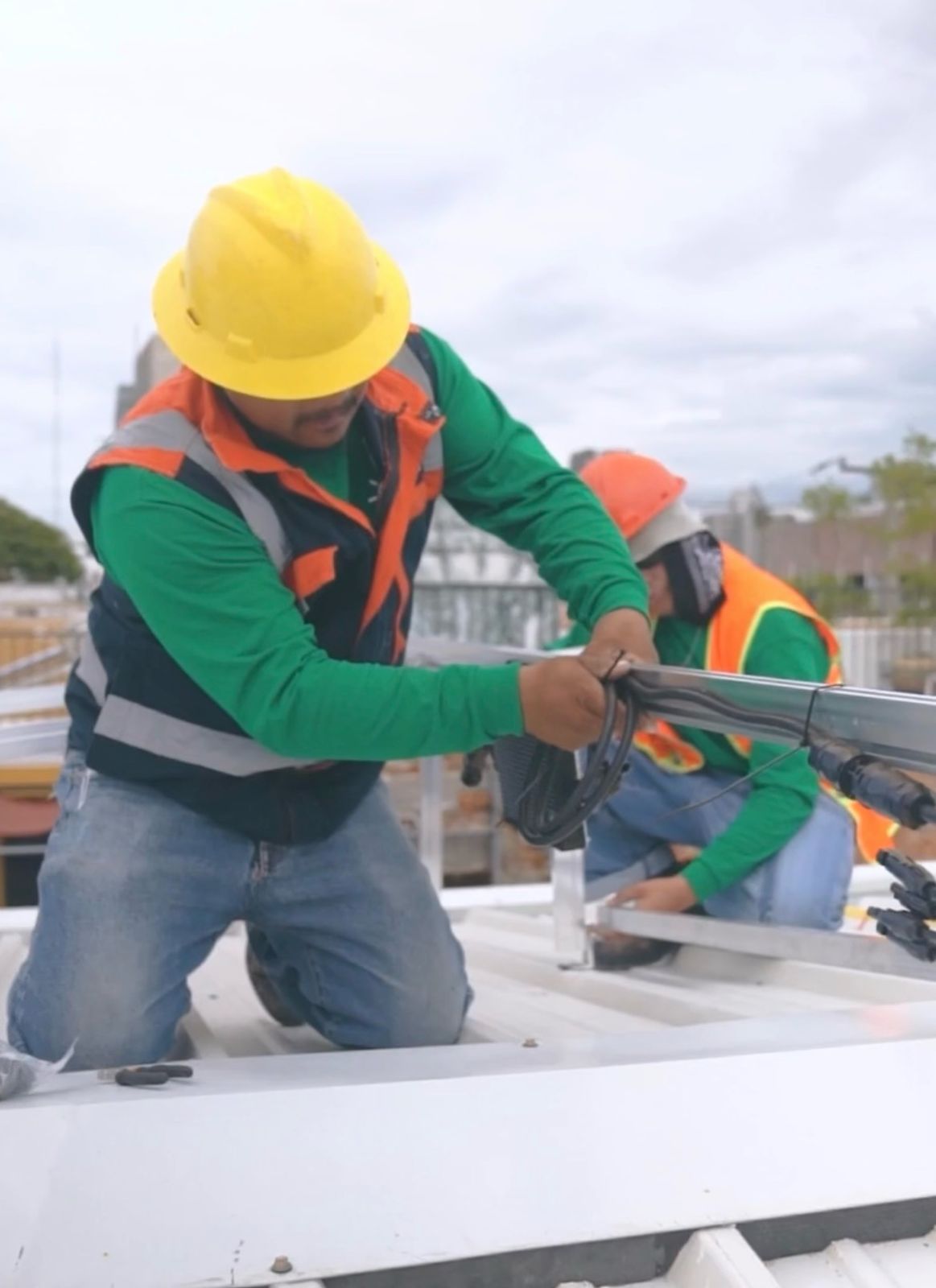 Installers fitting mounting structure on rooftop (PM Surya Ghar banner)